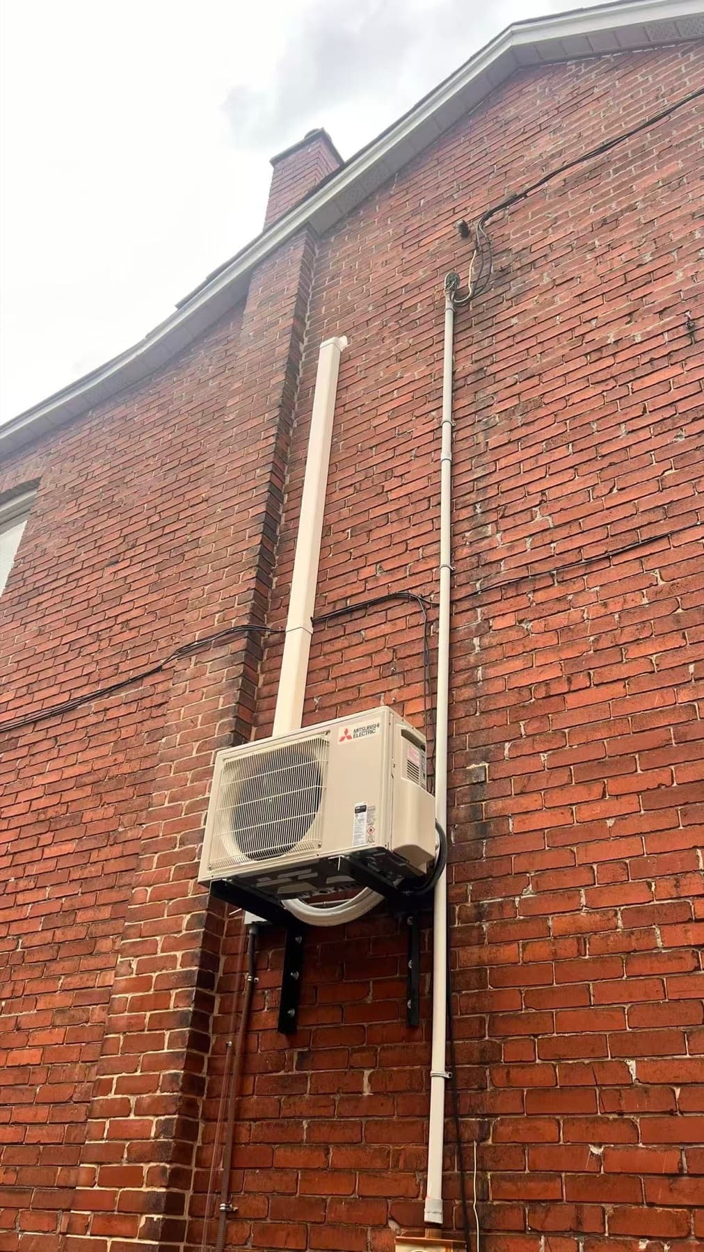 Mitsubishi mini-split outdoor condenser installed on brick